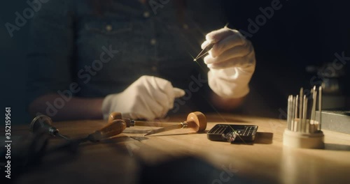 Jeweler taking a close look at a small diamond that gives spark-like flares of various colors