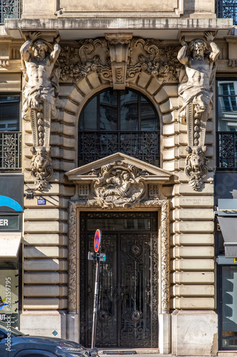 Paris, France - May 14, 2020: Old door with statues sculptured in the girder