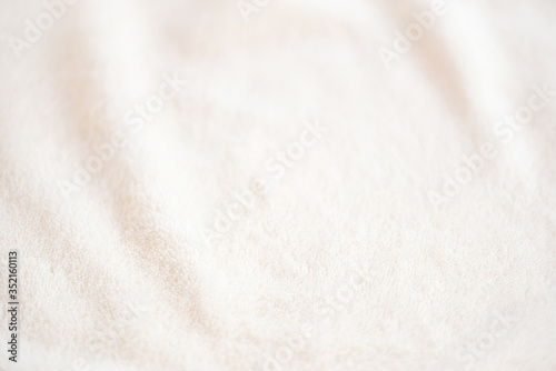 Soft cozy plaid made of white fabric with a pile lies in beautiful folds