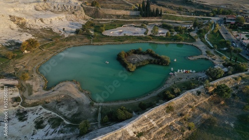 Aerial view of lake and famous Pamukkale travertines hot thermal springs in Turkey, Hierapolis ancient town. Unesco World Heritage Site. 
