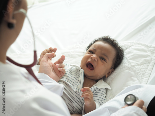 Shot of pediatrician examines african baby boy. Doctor using a stethoscope to listen to baby's chest checking heart beat. Concept health , lung disease , corona virus , covid19.
Sad child is crying. 