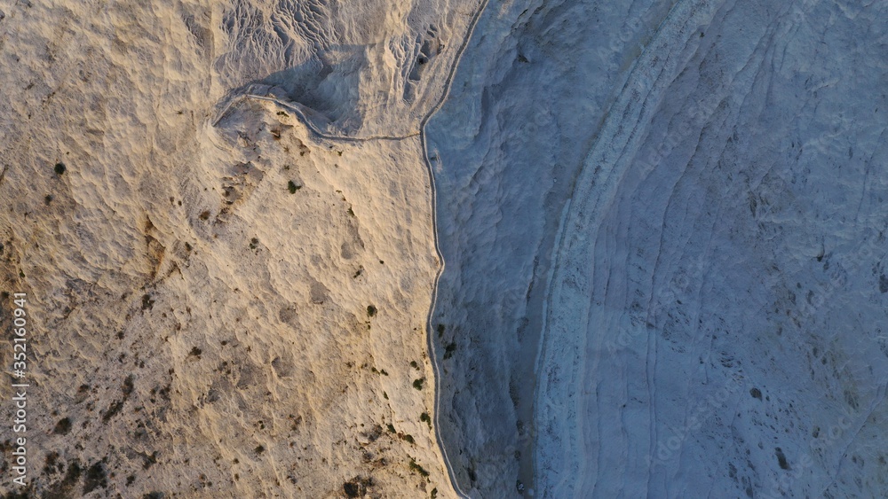 Obraz premium Aerial view of thermal pools hot springs tavertine terraces of Pamukkale natural park, white cotton castle, snow white mountains with carbonate mineral milky pools, Turkey 