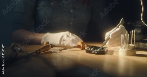 Jeweler taking a close look at a small diamond at a dusty room
