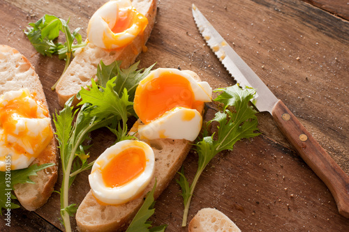Tasty soft boiled eggs and salad greens photo