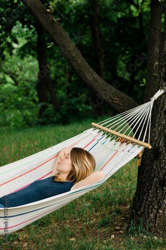Young woman relaxing in the hammock in nature