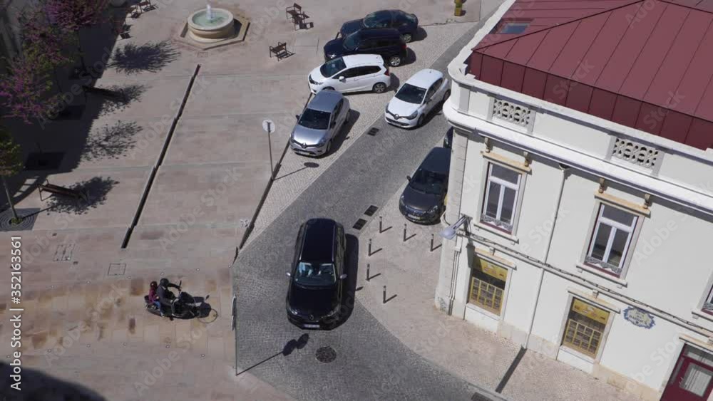 Tourists on moped wait for traffic in slow motion overhead view in Loulé, Portugal. Tourists on moped wait for traffic in slow motion overhead view in Loulé, Portugal.