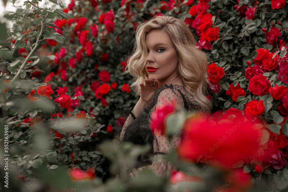 Beautiful blonde woman in garden with red roses. Beautiful blonde woman in garden with red roses.