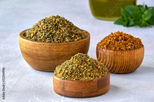 Fototapeta Naklejka Na Ścianę i Meble -  Mixed spice zaatar or zatar in wooden bowls, Various type of zaatar blend. Close up with copy space