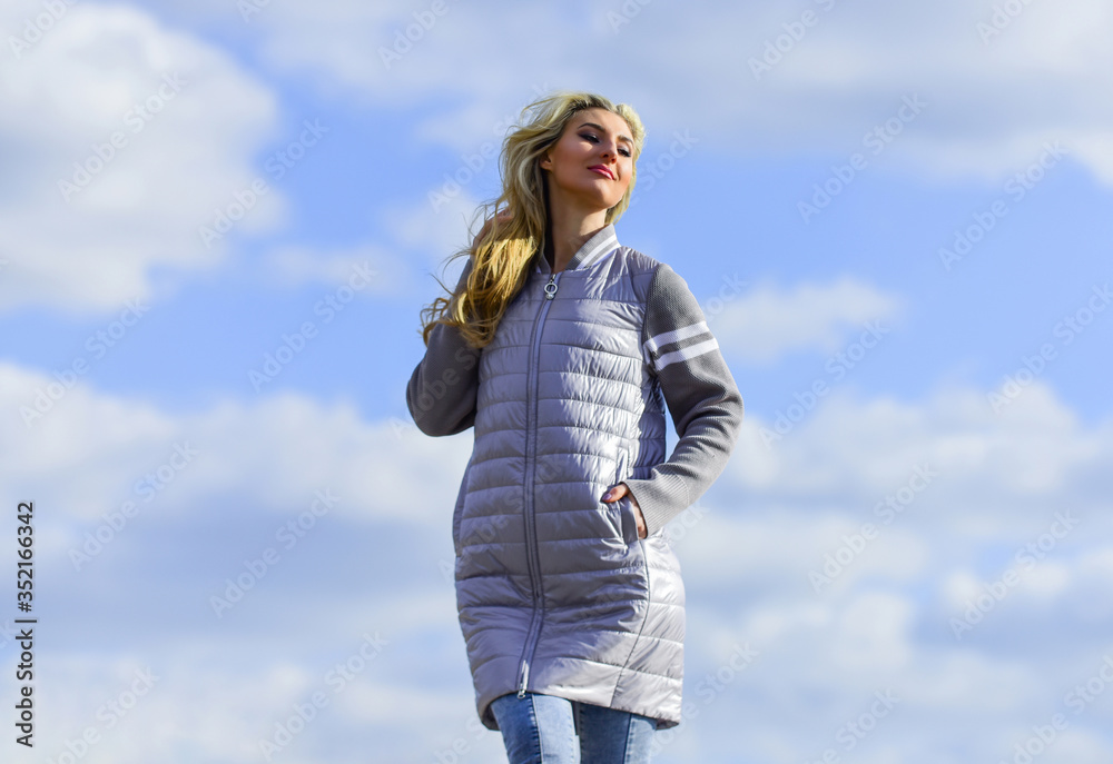 Windy day. Woman enjoying cool weather. Freshness of wind. Matching style and class with luxury and comfort. Beauty and fashion look. Girl jacket cloudy sky background. Woman fashion model outdoors