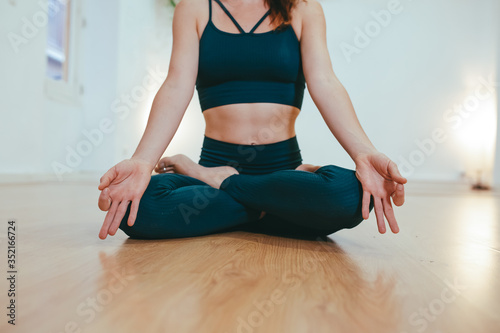 Yoga girl practicing meditation on white background with wooden floor