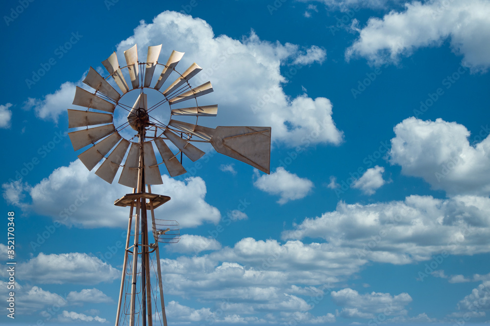 Image of old metal Wind mill against a blue sky Image of old metal Wind mill against a blue sky