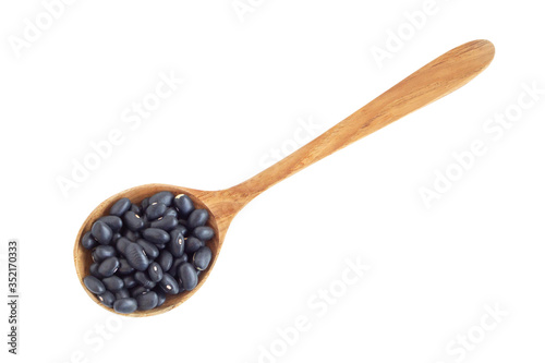 Closeup black beans seeds in wood spoon on white background, healthy food concept
