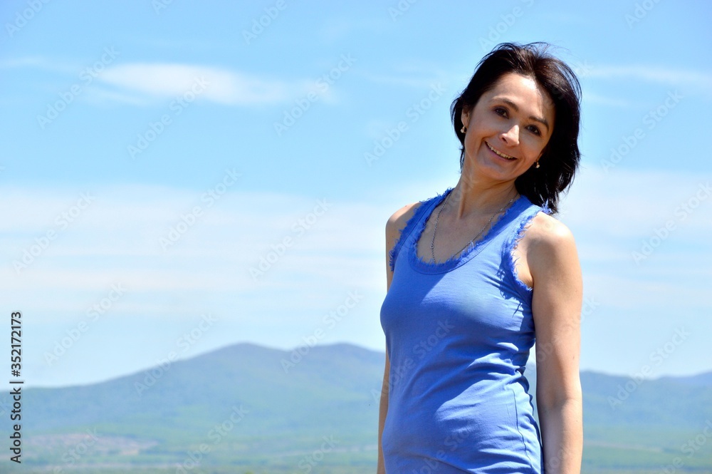 Young brunette woman smiling with teeth and looking at camera. sunny summer day Young brunette woman smiling with teeth and looking at camera. sunny summer day