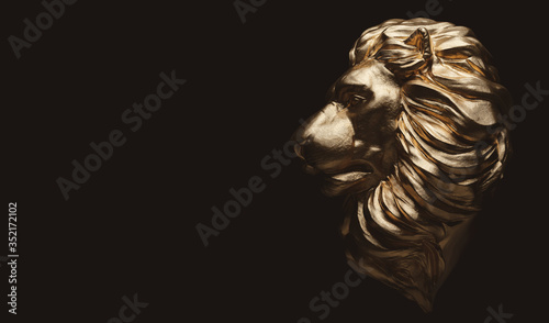 Lion statue, a gold sculpture. Concept of a guard, power and proud animal.