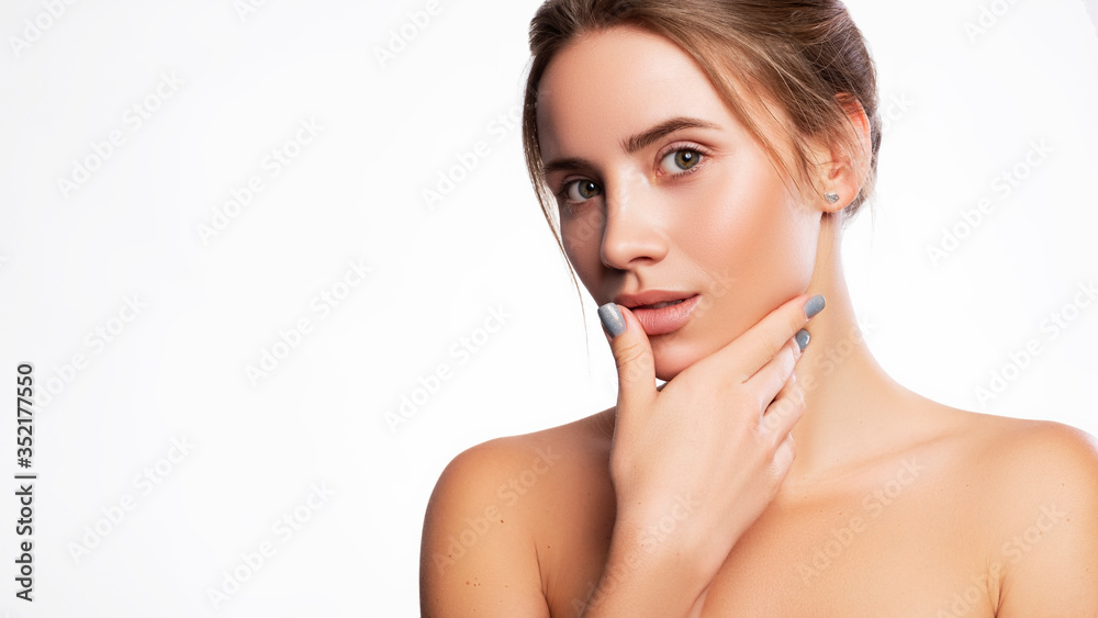 Close up of a brunette cute woman face with fresh clean flawless skin. She touches her face with her hand. Studio beauty portrait on white background Close up of a brunette cute woman face with fresh clean flawless skin. She touches her face with her hand. Studio beauty portrait on white background