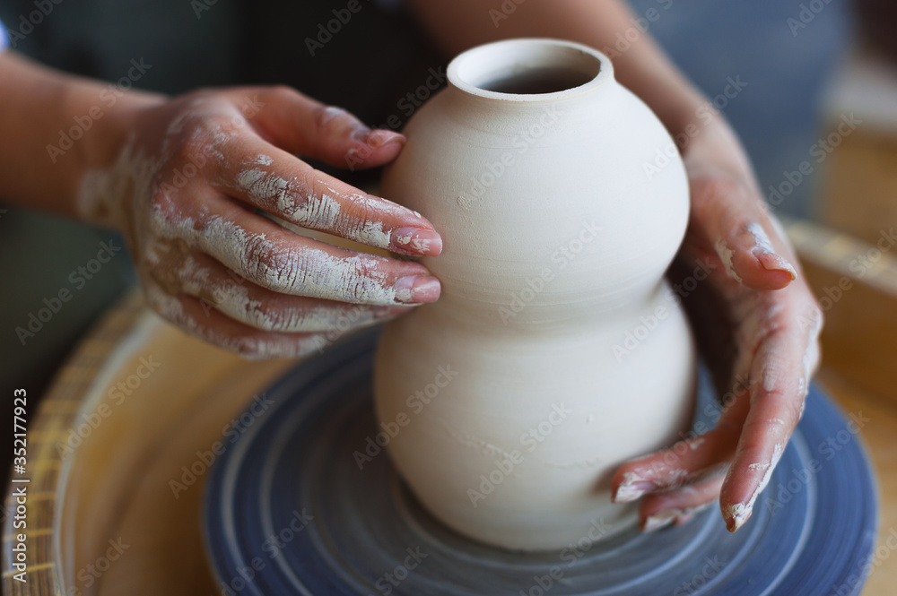 Hands working on pottery wheel Hands working on pottery wheel