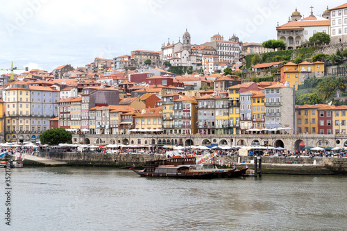 Porto, Portugal - 23 June, 2019: Traditional boats anchored on the Douro River with the Cais da Ribeira in the background, in the city of Porto, Portugal