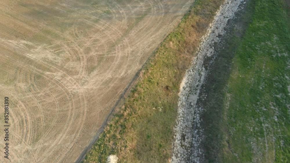Spiral raising aerial video above fields, spring blooming trees and fish pond Spiral raising aerial video above fields, spring blooming trees and fish pond