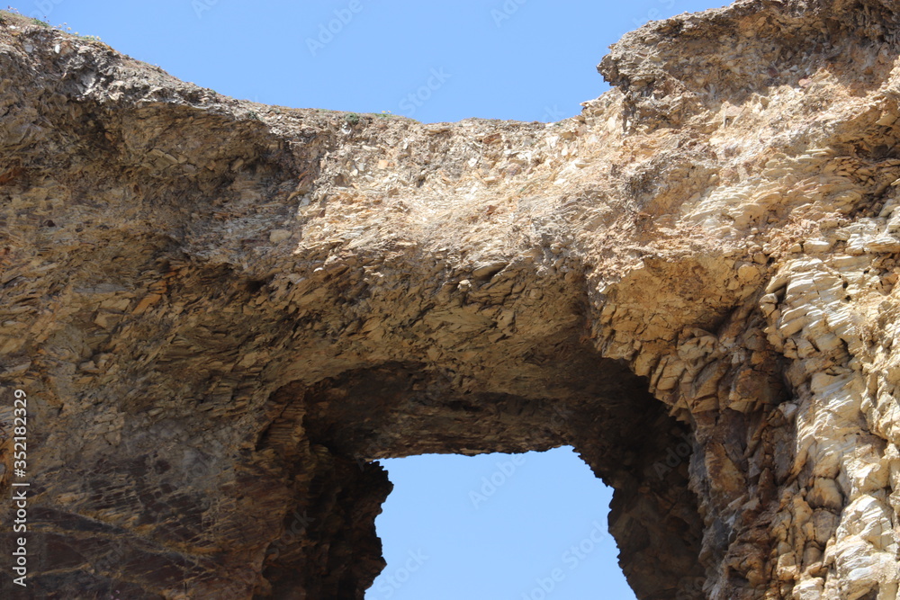 Close up of rocky arch with blue sky 