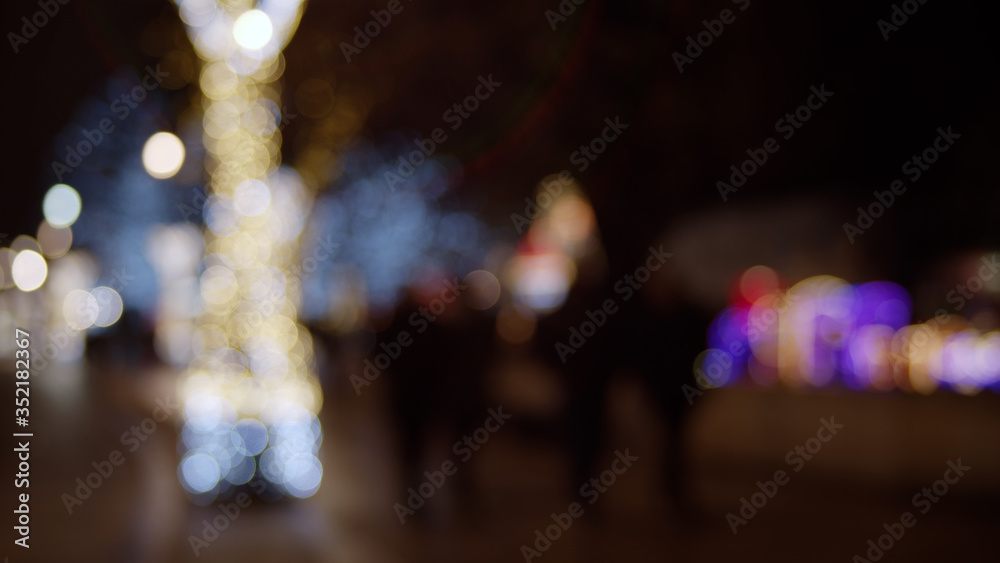 Abstract colorful defocused bokeh background. Blurred City street lights and reflections in rain at night.