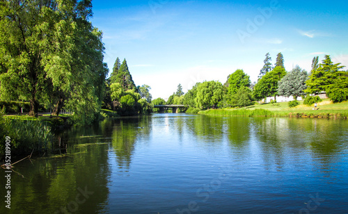 View of Meander River with The Meander River Bridge in the distance. Taken in Deloraine, a tourist destination town because of its proximity to the surrounding Tasmanian natural attractions 