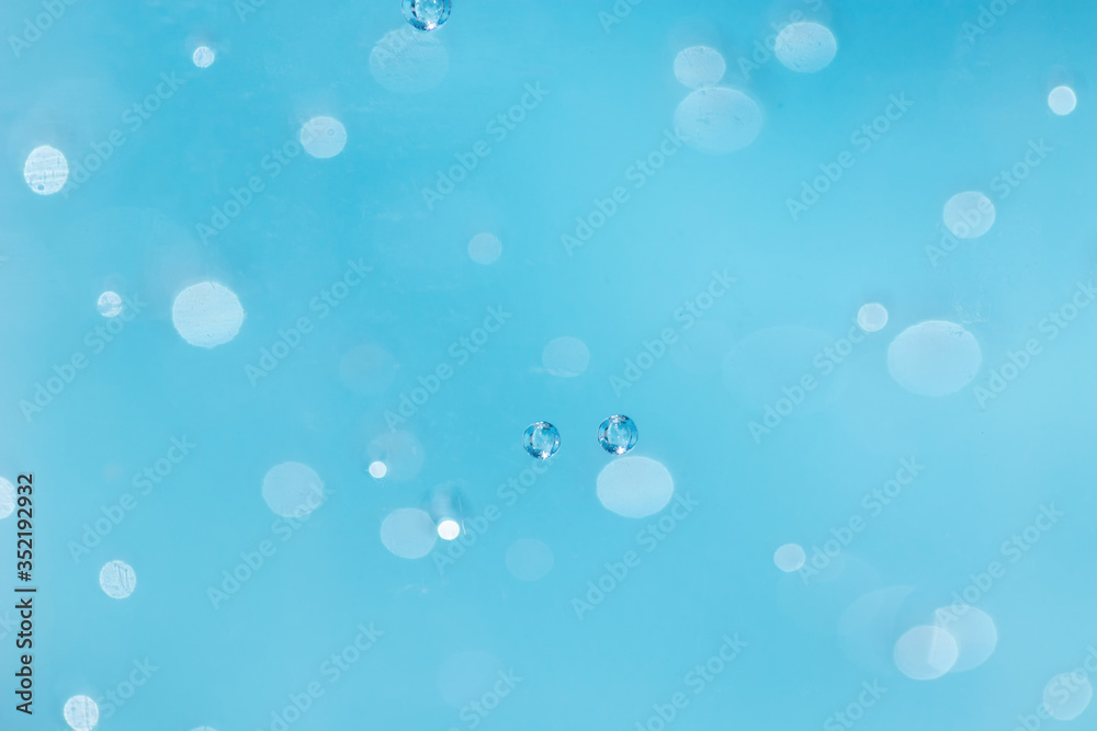 Bubbles are blurred from in the alcohol gel bottle and the blue background.