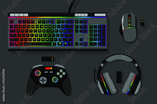 gamer workspace concept, top view a gaming gear, mouse, keyboard, joystick, headset, mobile joystick, in ear headphone and mouse pad on black table background with copy space.
