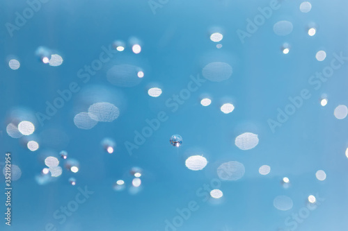 Bubbles are blurred from in the alcohol gel bottle and the blue background.