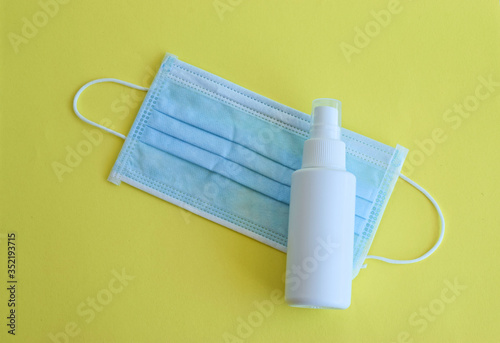 Antiviral medical mask and spray antiseptic bottle for protect against the virus , surgical blue mask on colorful lime background