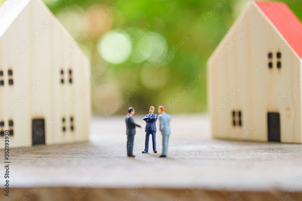 Miniature businessmen standing Investment Analysis Housing Or