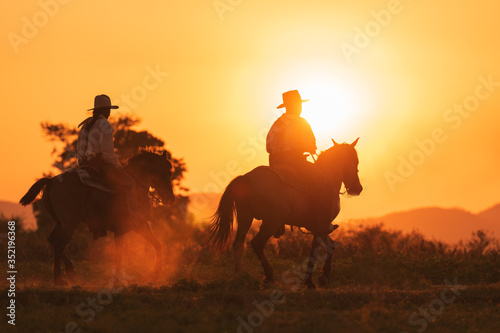 Fototapeta Naklejka Na Ścianę i Meble -  cowboy riding with horse in the sunset time