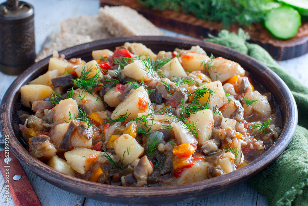 Vegetable stew with potatoes and eggplant in a clay bowl, vegetarian recipe, selective focus Vegetable stew with potatoes and eggplant in a clay bowl, vegetarian recipe, selective focus