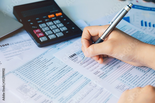 Close up woman hand filing US tax form. tax form us business income office hand fill concept.Individual income tax return form