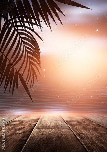 Fototapeta Naklejka Na Ścianę i Meble -  Sea evening landscape with sunset. Palm tree branches, silhouettes, sunlight. Wooden table by the sea. Night view, open-air seascape. 3D illustration