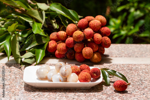 Lychee with leaves on gray background. Tropical fruit. photo