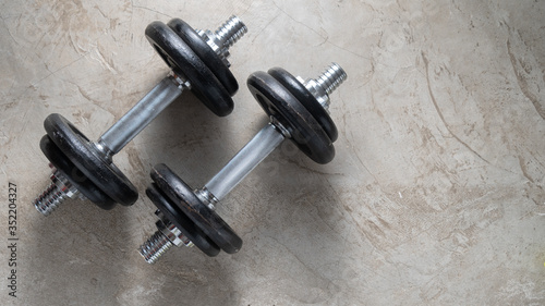 Dumbbells for muscle building exercise placed on cement floor with copyspace.Body workout in the gym training concept.new normal popular lifestyles for strong and healthy bodybuilding at home