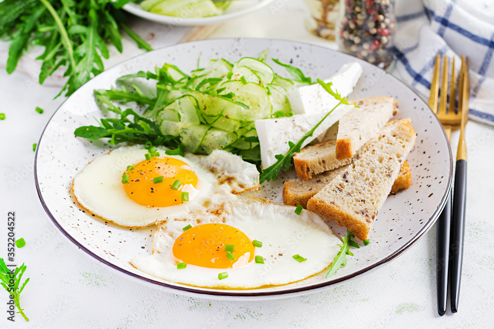 English breakfast - fried eggs, feta cheese, cucumber and arugula. American food.