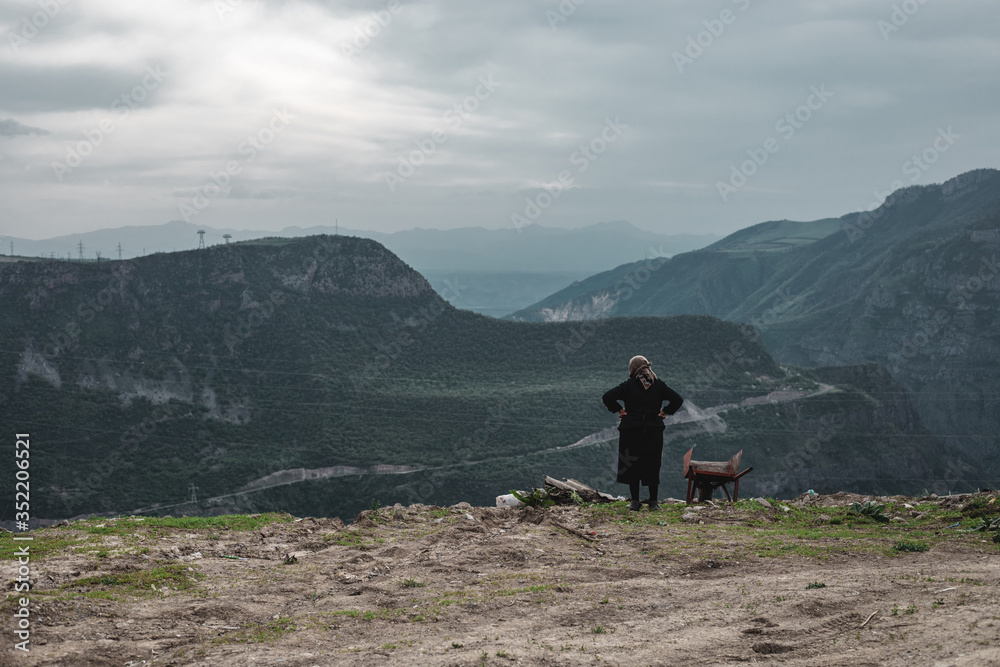 Old woman enjoying view from top of mountain. Armenia , Tatev.
