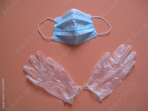 Guantes de plástico transparentes en parte inferior y mascarilla azul quirúgica en partesuperior