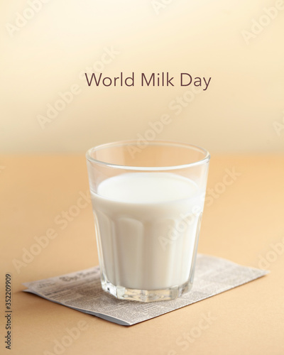  Glass cup with milk on a brown background with the inscription Milk Day. June 1st milk concept. Copy space.