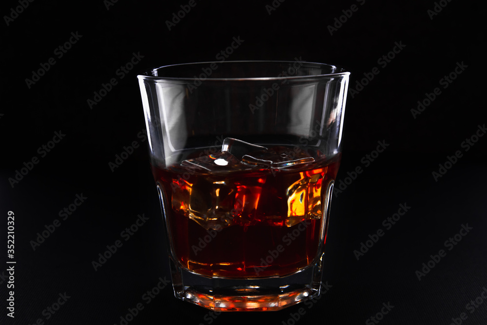 Glass with whiskey with ice on a dark background, isolate Glass with whiskey with ice on a dark background, isolate