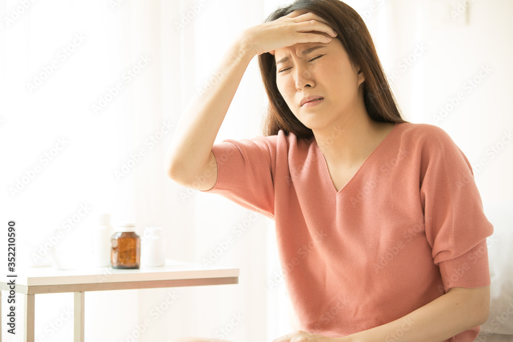 Women feel headaches and fever, sitting on the bed, sick. Health Care Concept, Virus Women feel headaches and fever, sitting on the bed, sick. Health Care Concept, Virus