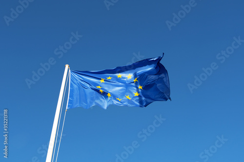 EU flag vawing in blue clear sky