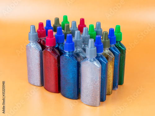 Multi-colored tubes with glitter on a yellow background