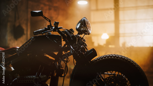 Custom Bobber Motorbike Standing in an Authentic Creative Workshop. Vintage Style Motorcycle Under Warm Lamp Light in a Garage. Profile View. photo