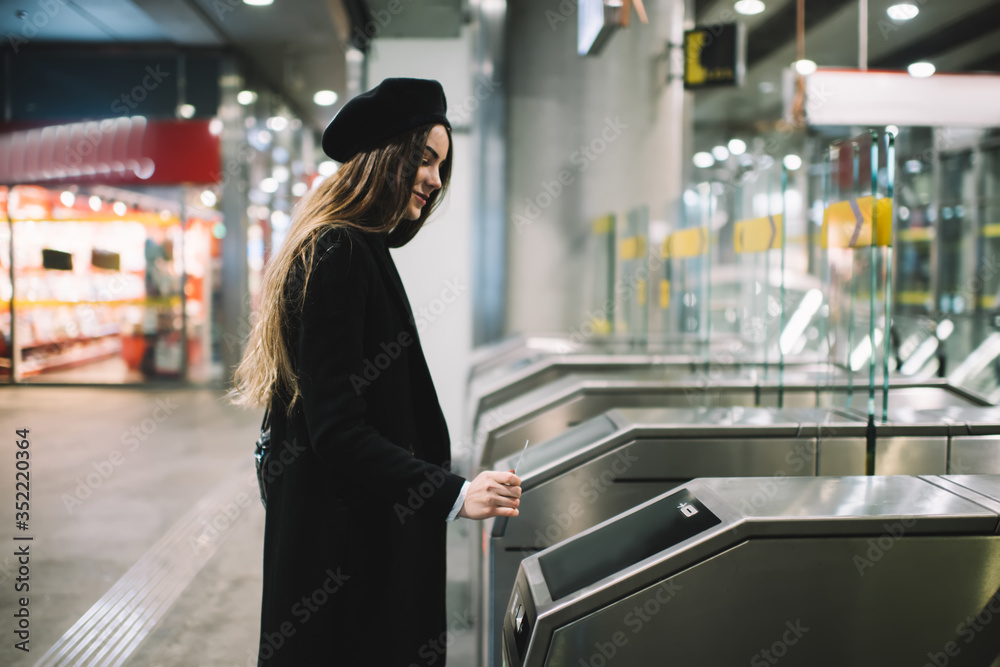 Ταπετσαρία Positive woman in warm outerwear going through turnstile in subway