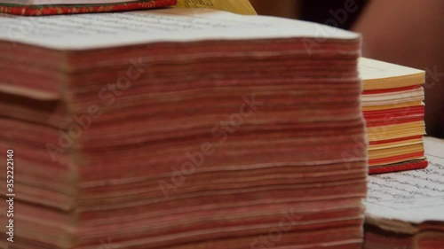 A monk's hand flips through Buddhist texts in a Tibetan monastery photo