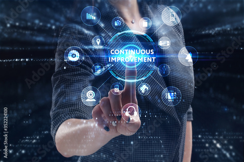 Business, Technology, Internet and network concept. Young businessman working on a virtual screen of the future and sees the inscription: Continuous improvement