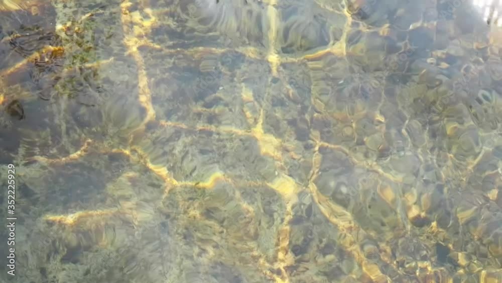 Close up water surface in the natural river with golden light reflections. Close up water surface in the natural river with golden light reflections.