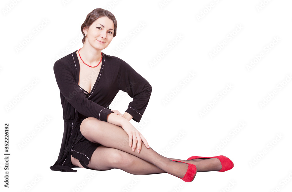 Portrait of a beautiful young woman in a black dressing gown and red shoes Portrait of a beautiful young woman in a black dressing gown and red shoes